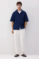 Pantalón blanco de lino liviano, corte recto, con elástico revestido y cordón ajustable en la cintura, bolsillos laterales y bolsillo trasero insertado.