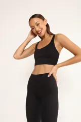Top deportivo negro con breteles finos cruzados en la espalda y almohadillas removibles.