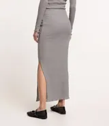 Pollera midi gris de rib acanalada con hilo metalizado, cintura elástica, abertura lateral y bajo ondulado.