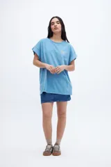 Musculosa celeste con estampado pequeño en el pecho, corte oversize y mangas con dobladillo.