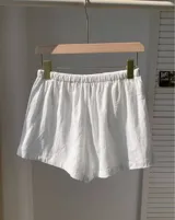 Short blanco de tela rústica con cintura elástica y cordón ajustable.
