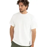 Remera blanca de algodón con cuello redondo y manga corta. Estampa pequeña en la parte inferior izquierda con un diseño abstracto en tonos marrones.