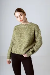 Sweater de punto color verde con detalles en amarillo y blanco, de corte holgado y cuello redondo.