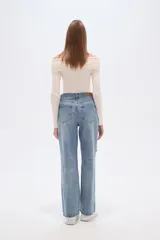 Pantalón jean azul claro, de corte recto y tiro alto, con roturas en las rodillas y detalles deshilachados en los bolsillos.