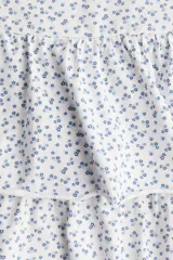 Minifalda blanca con estampado floral azul, cintura elastizada y corte escalonado con volados.