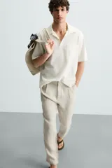 Pantalón de vestir blanco, confeccionado en lino, de corte recto, con bolsillos laterales y traseros. Se ajusta a la cintura con botón y cierre.