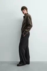 Camisa relaxed fit color verde militar, confeccionada en tejido con mezcla de modal. Tiene cuello solapa, manga larga con puño abotonado, bolsillo plastrón en el pecho y cierre frontal de botonadura.