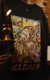 Remera negra de algodón con cuello redondo y calce oversize. Estampa sublimada con diseño inspirado en el arcano mayor del tarot 'El Loco' y logo de la marca.