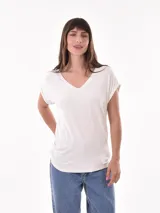 Remera blanca de corte holgado con cuello en V y mangas cortas con dobladillo.