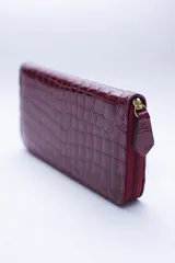 Billetera marrón con estampado de piel de serpiente, cierre perimetral, múltiples ranuras para tarjetas, documentos y billetes, y bolsillo interior con cierre para monedas.