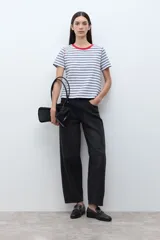 Remera de manga corta con rayas horizontales blancas y azul marino. Presenta cuello redondo con ribete rojo y costuras expuestas en rojo en los hombros.