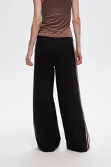 Pantalón negro ancho de viscosa con vivos laterales en blanco, dorado y marrón.