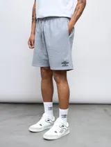 Bermuda deportiva gris melange de felpa, con cintura elástica y cordón de ajuste. Presenta bolsillos laterales y el logo Umbro bordado en la pierna izquierda.