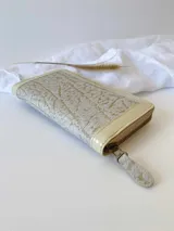 Billetera pequeña de cuero color beige con cierre metálico y monedero interno.