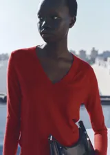 Suéter rojo de punto fino con cuello en V y mangas largas.