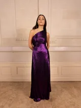 Vestido largo de fiesta color violeta metalizado, con textura plisada y diseño de un solo hombro.