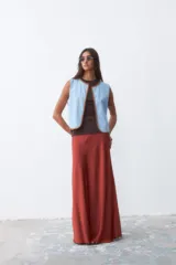 Chaleco celeste con terminaciones en crochet color marrón.