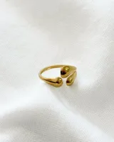 Anillo dorado de acero con diseño abierto y tres apliques redondeados.