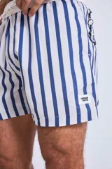 Short de baño azul marino con rayas verticales blancas, corte a la mitad del muslo y pretina elástica.
