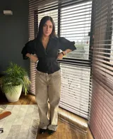 Camisa negra de lino con corte a la cintura y lazo ajustable. Mangas cortas abullonadas.