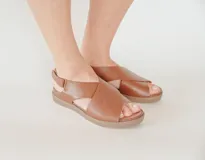 Sandalias de cuero color marrón con tecnología Antistress. Presentan tiras cruzadas en el empeine, plantilla anatómica de PU con acción antibacteriana y suela de poliuretano.