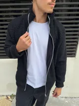 Campera negra símil corderito con cierre frontal y cuello alto.