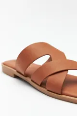 Sandalia plana color marrón con tiras anchas cruzadas, punta cuadrada y base levemente acolchonada.