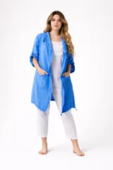 Campera larga tipo sobrecamisa o saco ligero de lino, color azul vibrante. Presenta cuello solapa, mangas largas enrolladas con presilla y bolsillos frontales. El ruedo es asimétrico con terminaciones de cordones.