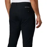 Pantalón de vestir negro, de corte recto, con bolsillos laterales y traseros. Se ajusta a la cintura con cinturón de cuero marrón.
