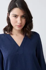 Blusa color crudo con escote en V y mangas largas.