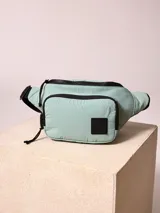 Riñonera negra de nylon arrugado con dos compartimentos con cierre y logo de la marca en relieve.