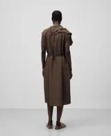 Vestido marrón de lino con escote en pico, manga sisa caída, volante con acabado desflecado en el delantero y cinturón. 