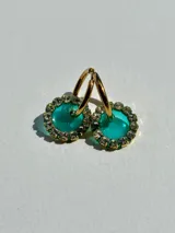 Par de aros dorados con dije circular de resina color terracota con glitter y borde de strass.