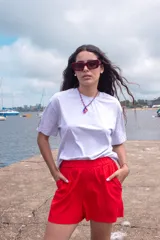 Remera blanca de algodón con cuello redondo y manga corta. Presenta un parche con diseño de paisaje en la manga izquierda.