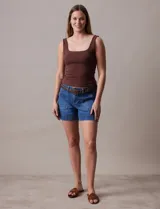 Short de jean azul con bolsillos delanteros y traseros, pretina con pasadores, cierre y doble abotonadura. Incluye cinturón trenzado de cuero marrón.