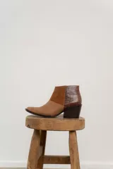 Bota corta de cuero color marrón con paneles de gamuza y cuero texturizado.