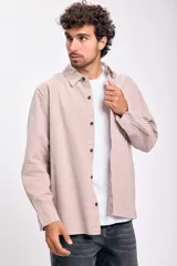 Camisa de manga larga color beige con botones negros.