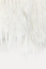 Chaqueta de pelo sintético color blanco, de cuello redondo y manga larga. Tiene bolsillos delanteros, forro interior y cierre frontal con ganchos metálicos forrados.