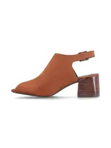 Sandalia tipo mule color coñac, con puntera abierta (peep-toe) y taco ancho de madera con vetas oscuras. Presenta un corte asimétrico en el empeine y tira ajustable con hebilla metálica en el lateral.