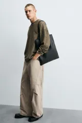 Pantalón de jean color beige, corte holgado y amplio en toda la pierna, tiro medio, tejido rígido, cinco bolsillos, efecto lavado y detalle de pinzas en perneras.