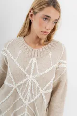 Sweater de mohair color crema con diseño de telaraña bordado a mano en negro.