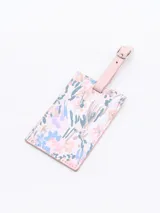 Identificador de maleta rectangular con estampado floral en tonos pastel y correa de ajuste rosa.