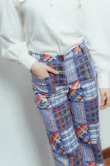 Pantalón largo de gabardina elastizada con estampado patchwork a cuadros en tonos azul, rojo, amarillo y negro.