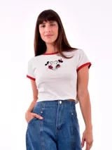 Remera corta blanca con cuello y mangas con ribete rojo. Estampado frontal de Minnie y Mickey Mouse abrazados.