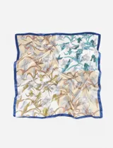 Pañuelo cuadrado de seda con estampado floral en tonos beige, blanco, verde y azul, con borde azul.