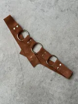 Cinturón de cuero con argollas plateadas, regulable desde 70 cm hasta 110 cm.