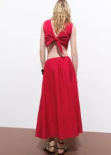 Falda larga evasé color fucsia, de tiro medio y cierre lateral con cremallera.