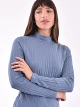 Polera rosa de tejido canalé, con cuello alto y mangas largas.
