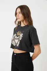 Remera cropped negra con estampa de corazón sagrado con rosas y estrellas.