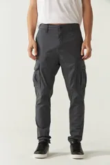 Pantalón cargo gris para hombre, de corte regular, con bolsillos laterales y traseros con solapa, pasacinto y logo metálico. Confeccionado en algodón y spandex.